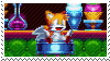 An animated stamp showing Tails from Sonic Mania spinning in a saloon chair. Behind the counter are a vial of unknown purple substance, a milkshake and a classic icecream cone.